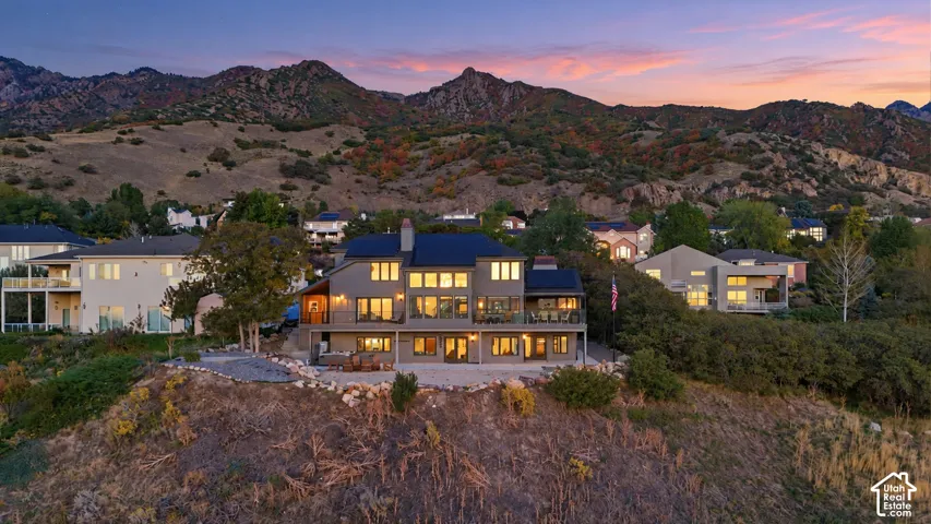 Multi-story residence featuring a dark roof, multiple balconies, and extensive window placements