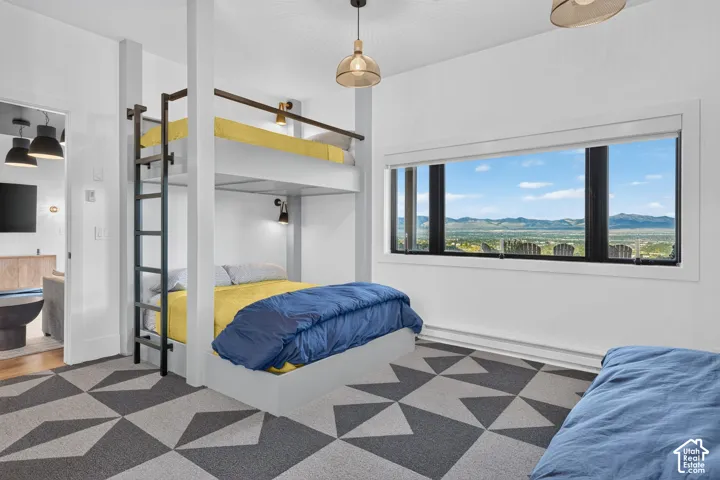Built-in bunk beds with integrated wall sconces, large horizontal window, geometric pattern area rug, and contemporary pendant lighting