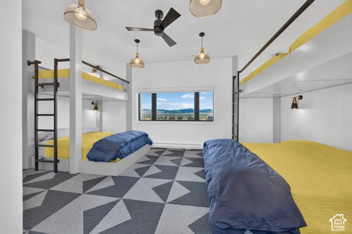 Built-in bunk beds with integrated ladders, geometric patterned carpet, and a large picture window with distant mountain scenery