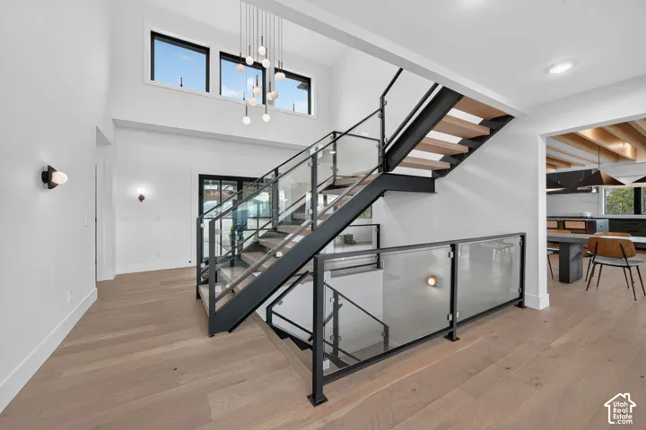 Two-story entryway featuring wood-finish flooring and a contemporary chandelier