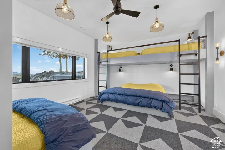 Geometric pattern flooring, built-in bunk beds with ladders, multiple lighting fixtures, ceiling fan, and expansive horizontal window