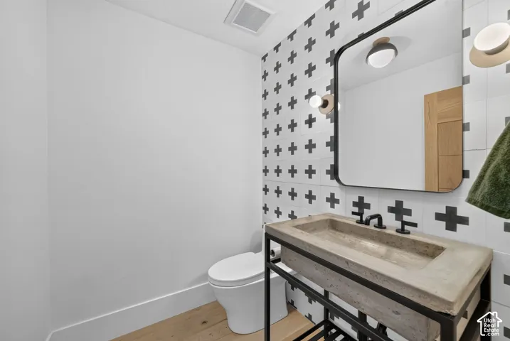 Concrete basin with a black metal frame, black faucet, and modern wall-mounted light fixtures