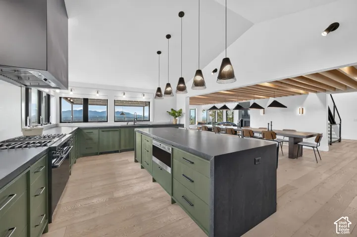Spacious kitchen with vaulted ceilings, a large center island, and wood-finish flooring