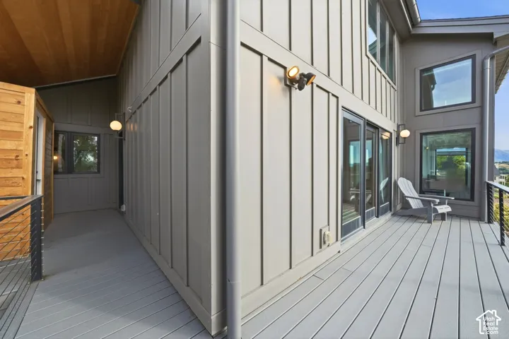 Exterior featuring board and batten siding, multiple windows, a composite deck, and a wood-paneled soffit