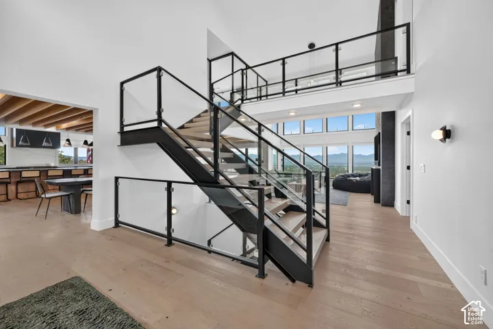 Contemporary open-tread staircase with glass and black metal railings