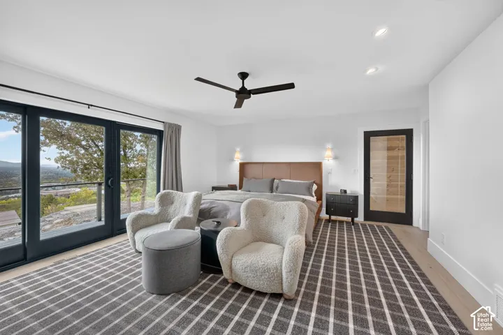 Wide plank wood-finish flooring, recessed ceiling lighting, and a modern ceiling fan