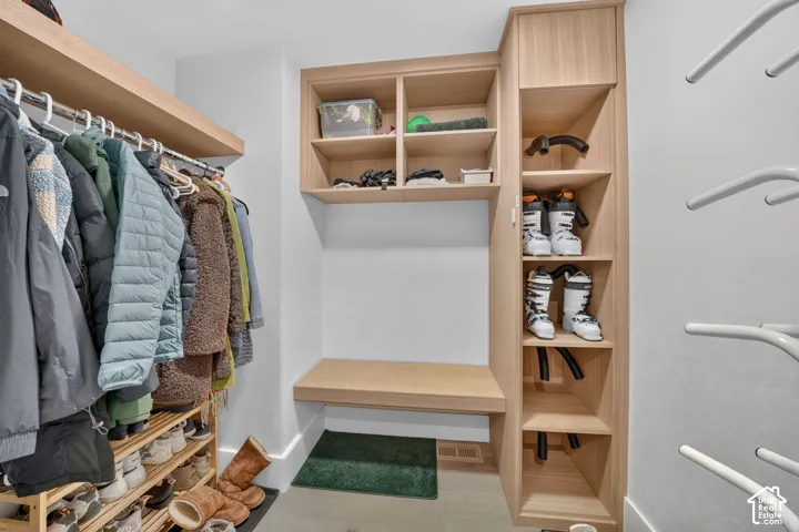 Integrated storage system featuring wood-finish shelving, a built-in bench, and dedicated boot drying racks