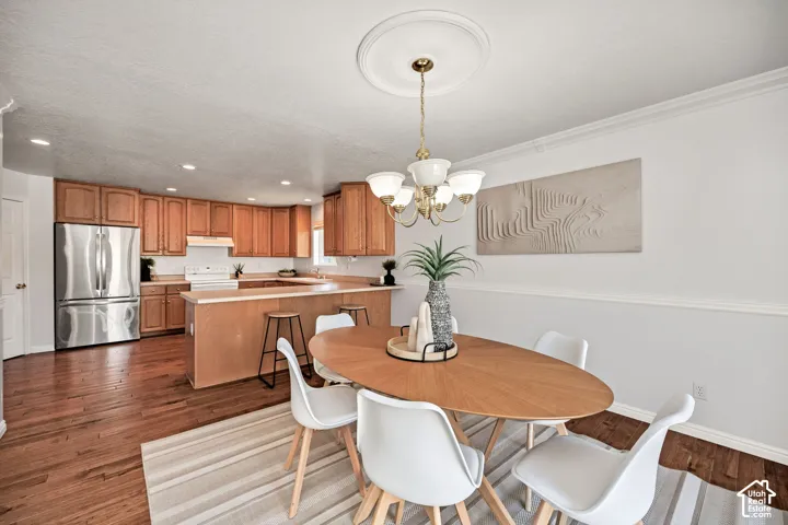 Wood-finish flooring throughout, with a kitchen featuring wood cabinetry and stainless-steel appliances