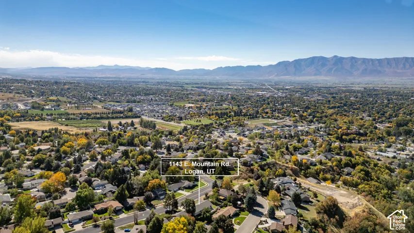 Mountain backdrop, expansive terrain, residential area, and diverse tree coverage