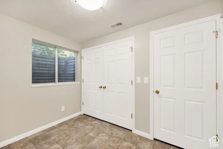 Recessed window, paneled doors, tile flooring, and overhead lighting