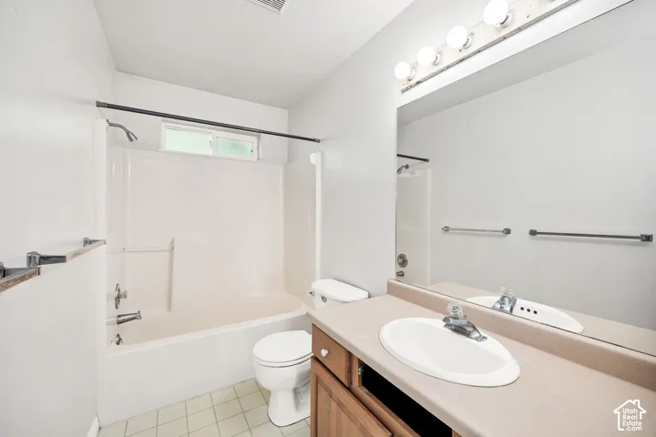 Bathroom featuring a combination bathtub and shower, built-in vanity with integrated sink, and wood-finish cabinetry
