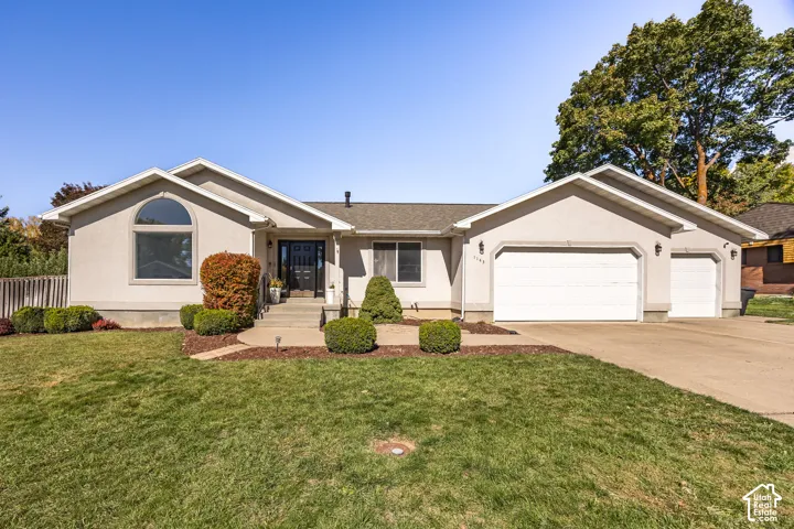 Stucco exterior with an arched window, a two-car garage, and a single-car garage