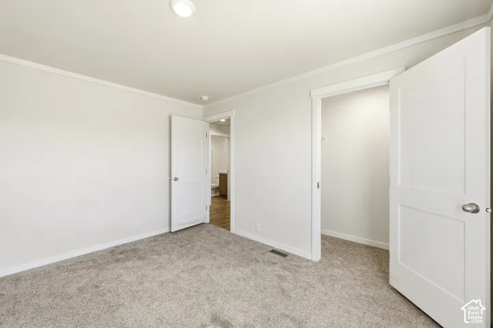 Neutral-toned carpeting, white walls, and a recessed ceiling light fixture