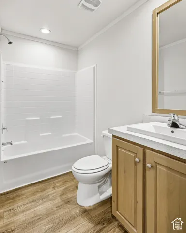 Wood-finish flooring with a light wood-tone vanity, white countertop, and integrated sink