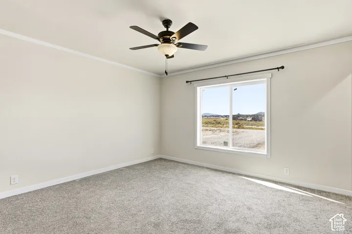 Light gray carpet flooring, white trim, a large window, and a ceiling fan with integrated lighting