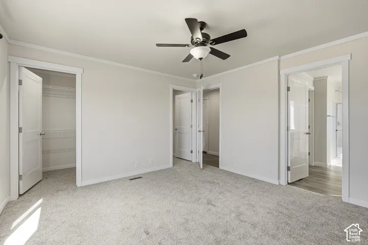 Neutral-toned carpeting throughout, crisp white trim, and a ceiling fan with integrated lighting