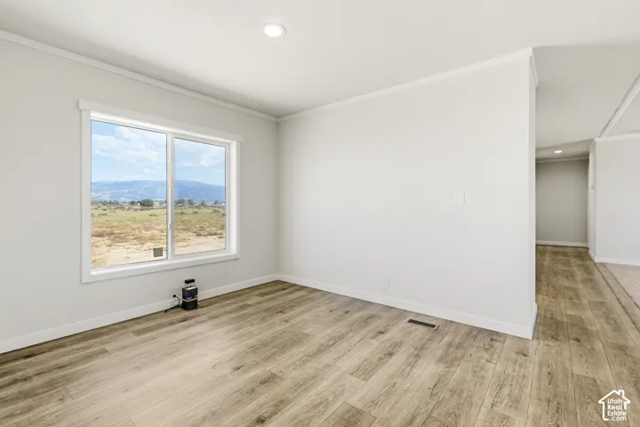 Recessed ceiling lighting, wood-finish flooring, white trim, and a large window with a distant mountain landscape