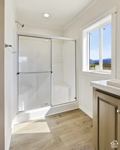 Shower with glass enclosure, built-in bench, and chrome fixtures