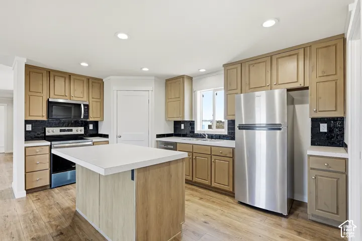 Kitchen featuring wood-finish flooring, recessed lighting, and a center island with a light-toned countertop