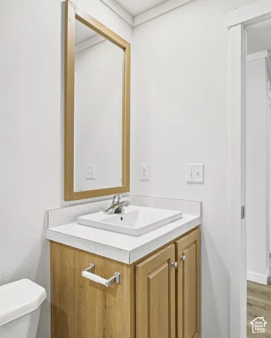 Wood-finish vanity with a white countertop and an integrated sink