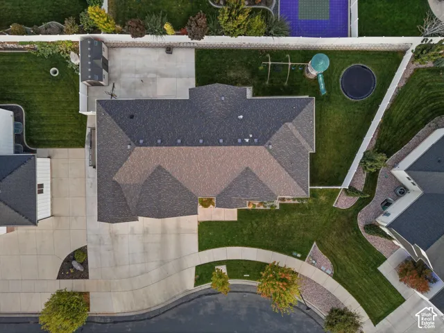 Expansive property featuring a multi-gabled roof, concrete driveway, manicured lawn, and mature landscaping