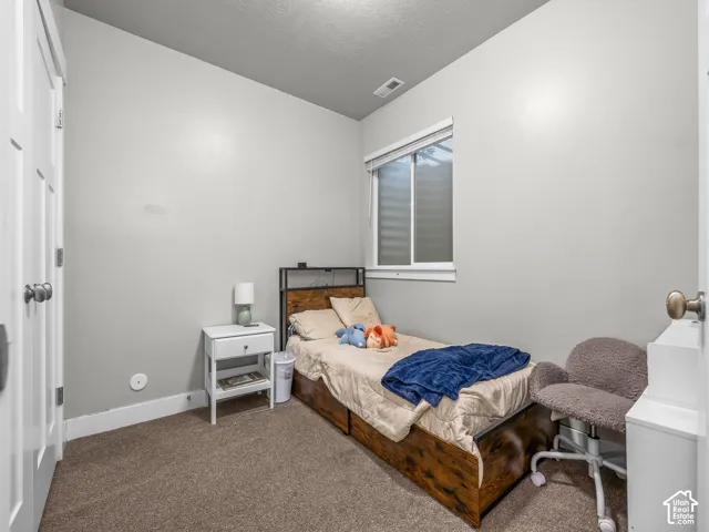 Neutral wall paint, window with blinds, and carpeted flooring