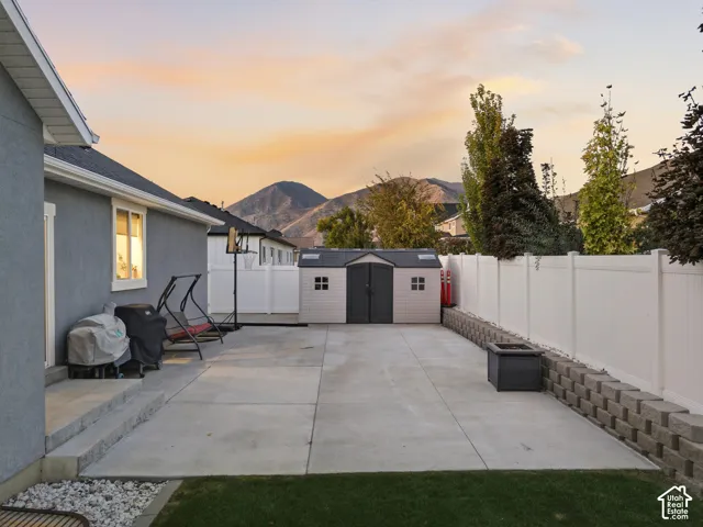 Expansive concrete patio with a white privacy fence and retaining wall