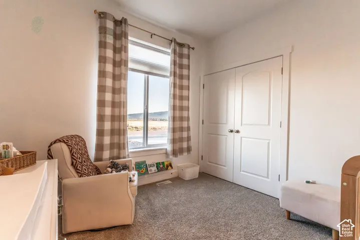 Wall-to-wall carpeting and white walls with a window featuring horizontal blinds