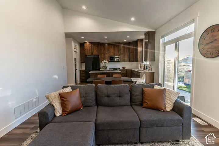 Vaulted ceiling, recessed lighting, wood-finish flooring, full-height windows, dark wood cabinetry