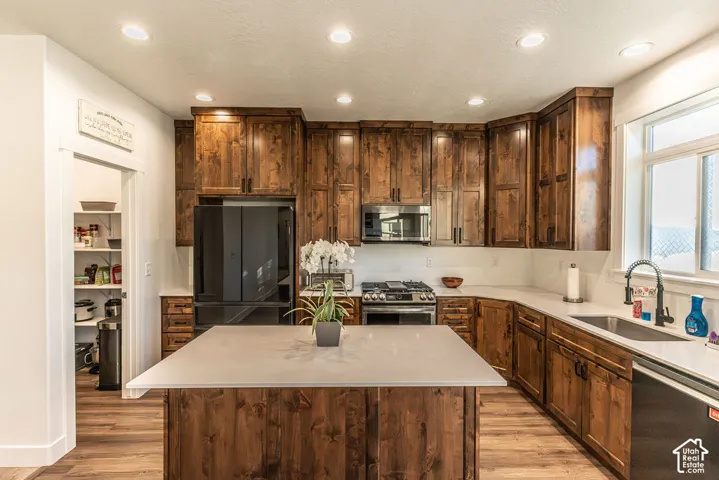 Kitchen featuring wood-finish cabinetry, light-toned countertops, and a central island