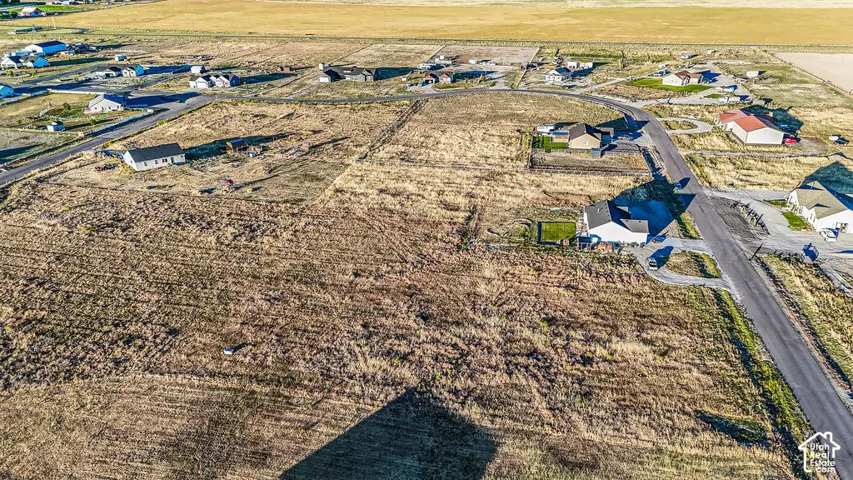 Expansive, undeveloped land parcel with surrounding residential properties