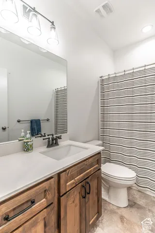 Wood-finish vanity with white countertop, undermount sink, and matte black faucet