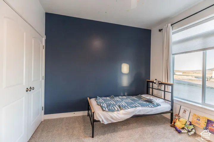 Wall-to-wall carpeting with a bright window, providing natural illumination