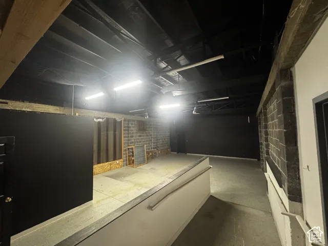 Concrete flooring, exposed ceiling beams, block wall construction, linear fluorescent lighting, and a built-in counter