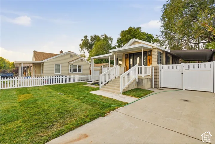 Single-family residence with a front porch, white picket fence, and a driveway