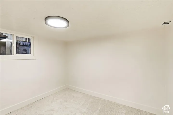 Recessed window with white trim, wall-to-wall carpeting, and a ceiling-mounted light fixture