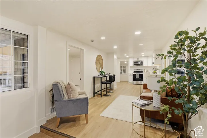 Open-concept living area with wood-finish flooring, recessed lighting, and white walls