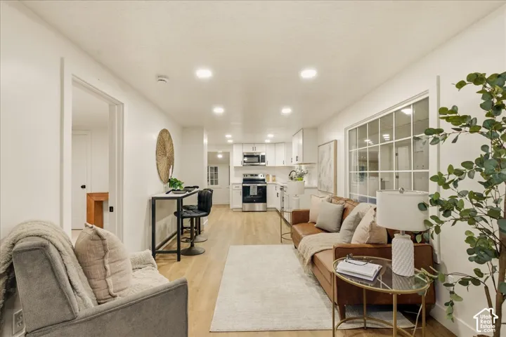 Open-concept living area featuring wood-finish flooring and recessed lighting