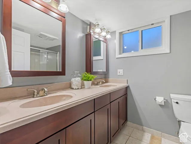 Basement bath with dual sinks, dual mirrors, and large shower