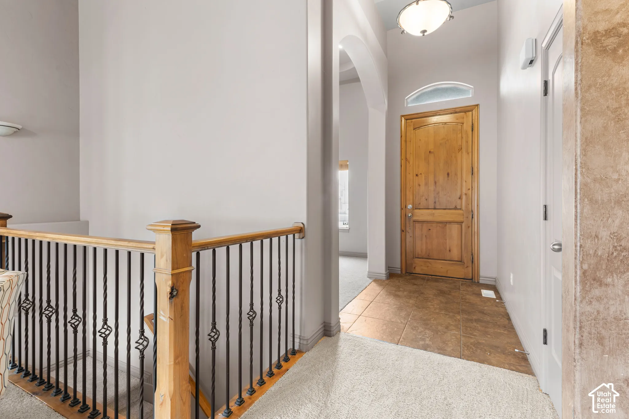 Wood entry door with an arched transom window, set within an arched entryway