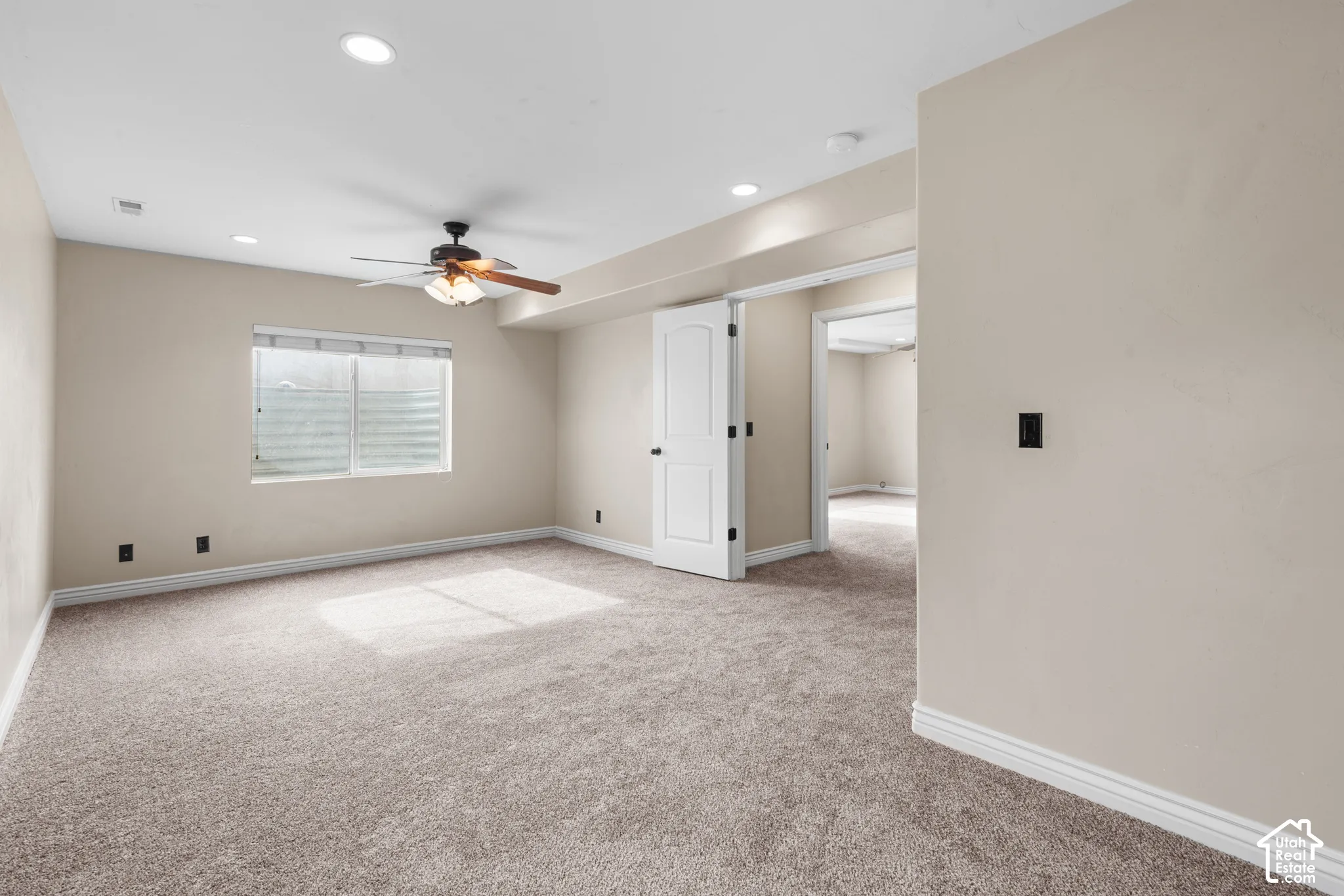 Recessed lighting, wood-finish ceiling fan, window with horizontal blinds, neutral wall paint, and plush carpet