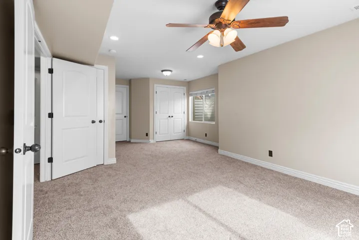 Neutral-toned carpeting, recessed lighting, ceiling fan with light fixture, and white trim