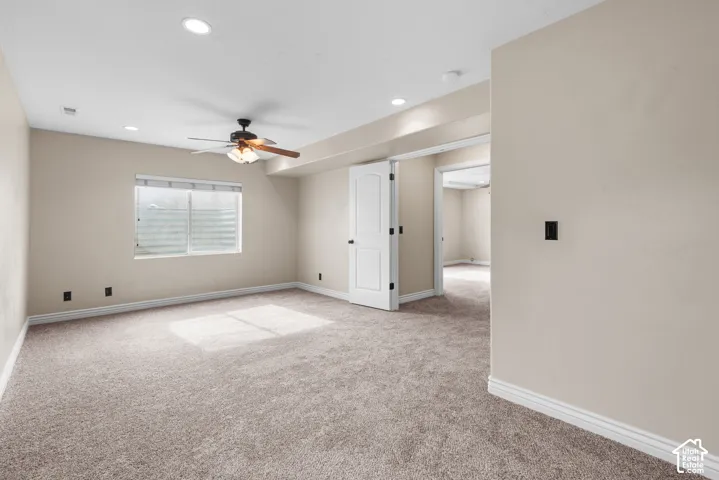 Recessed lighting, wood-finish ceiling fan, window with horizontal blinds, neutral wall paint, and plush carpet