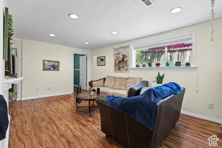 Recessed lighting, wood-finish flooring, and a large window with white trim