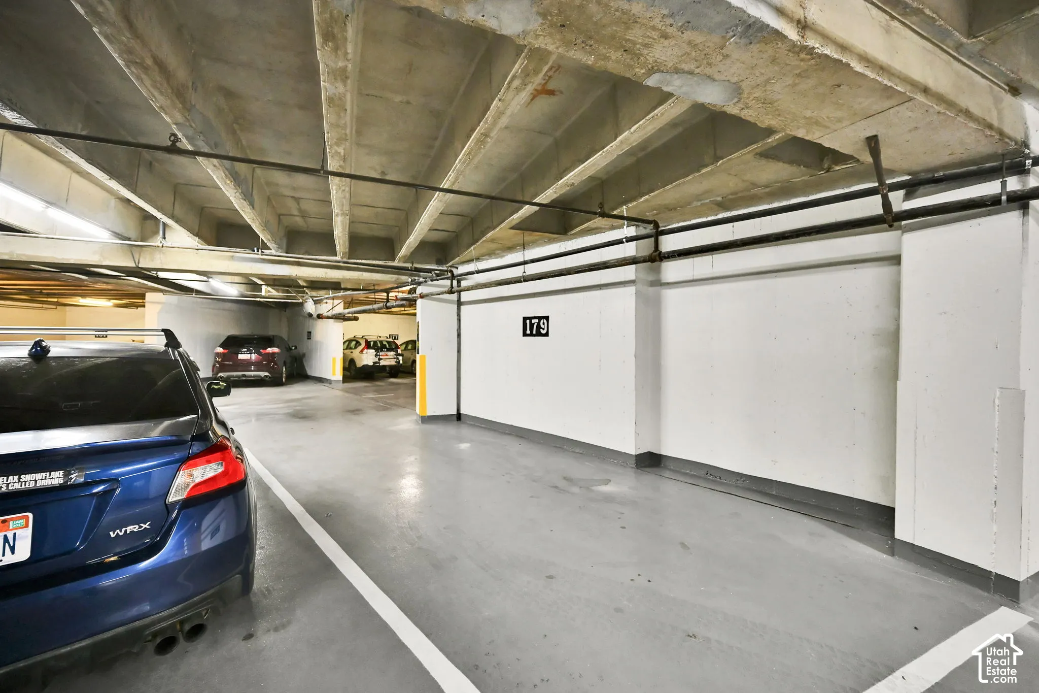 Parking garage featuring concrete slab ceilings and painted concrete walls