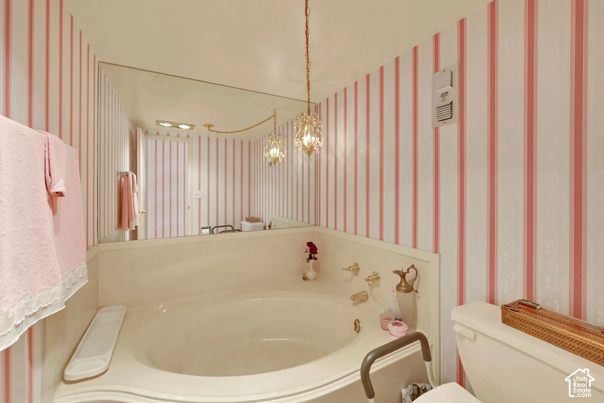 Built-in soaking tub with deck-mounted faucet and controls, complemented by a large wall-mounted mirror