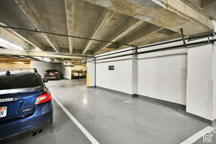 Parking garage featuring concrete slab ceilings and painted concrete walls
