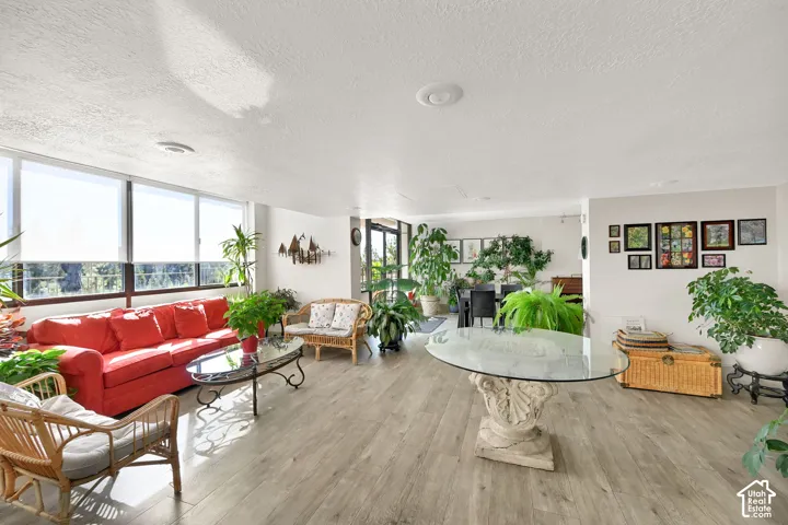 Expansive living area with wood-finish flooring, recessed lighting, and large windows