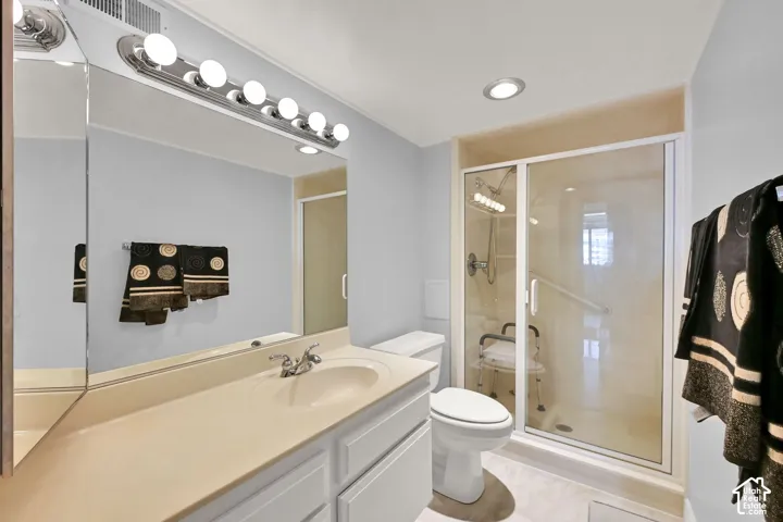 Bathroom featuring a single vanity with an integrated sink, framed mirror, and built-in lighting