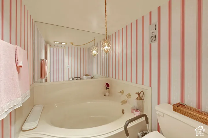 Built-in soaking tub with deck-mounted faucet and controls, complemented by a large wall-mounted mirror